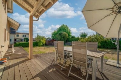 Terrasse avec table chaise et parasol d'une maison à vendre à St-Prex en Suisse